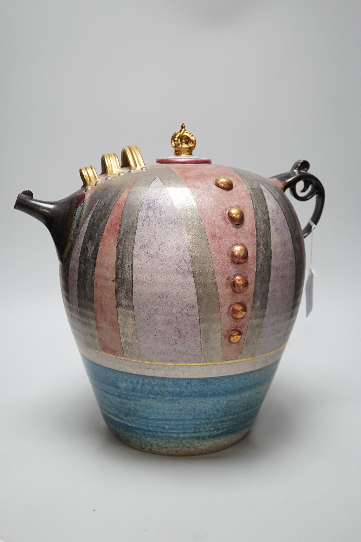 A Doug Bignell 'Mad Hatter's Tea Party' teapot and a hand needle worked tea cosy, inscribed “Nice drop of regimental sergeant majors”(specially commissioned by the current owner), teapot 35cms high
